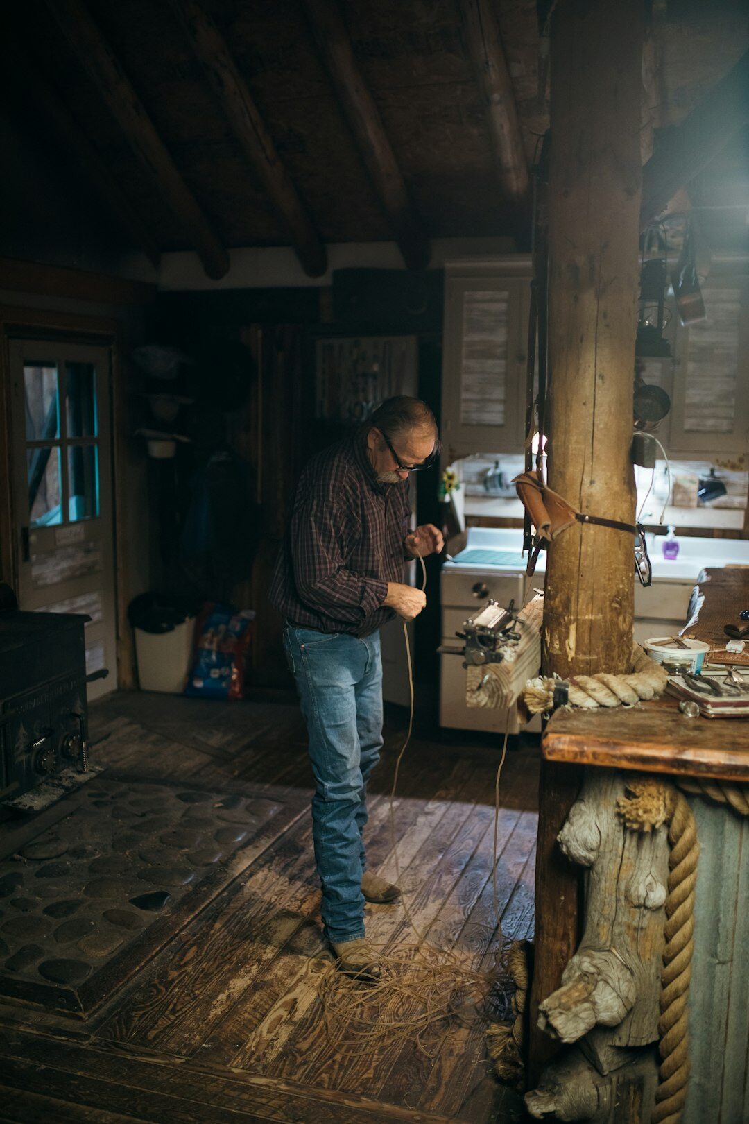 Photographer crouching to photograph a local craftsman at work in his workshop