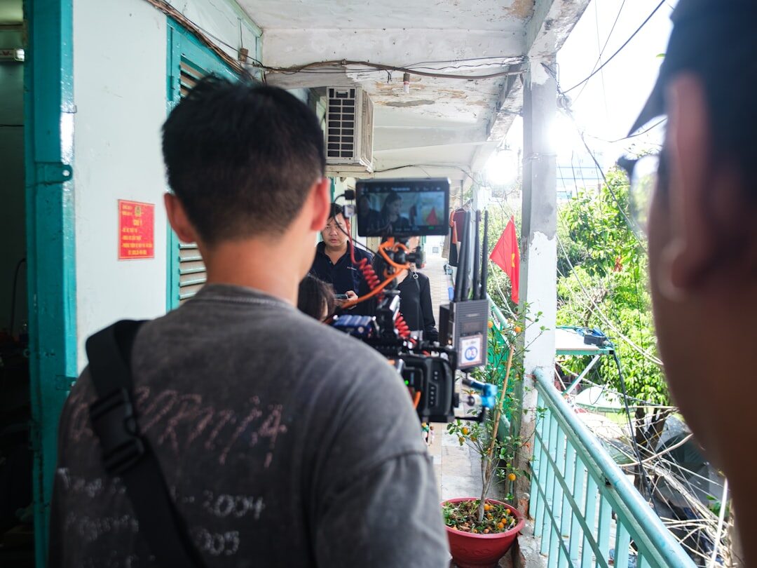 Photographer interviewing a local resident with a notebook and film camera nearby